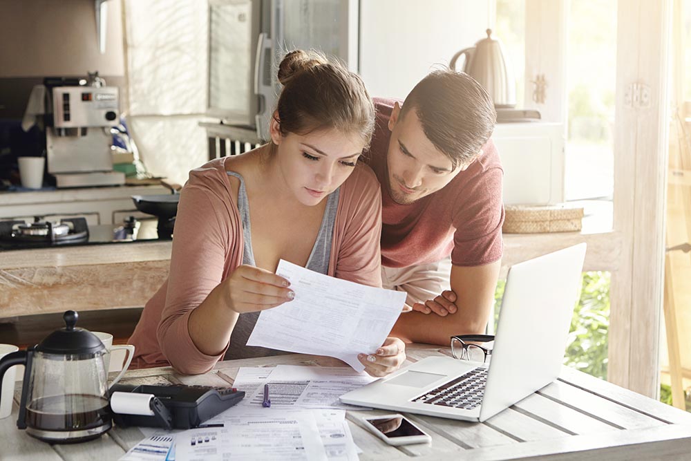 couple at the kitchen table reviewing finances and examining bills