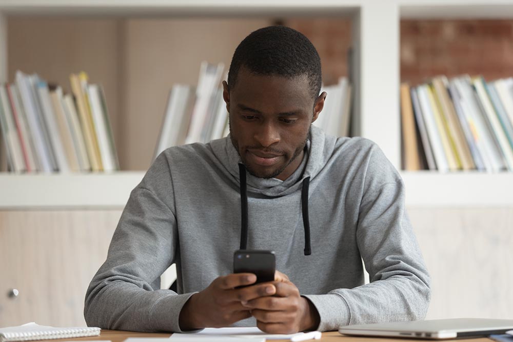 man using a smartphone in a library